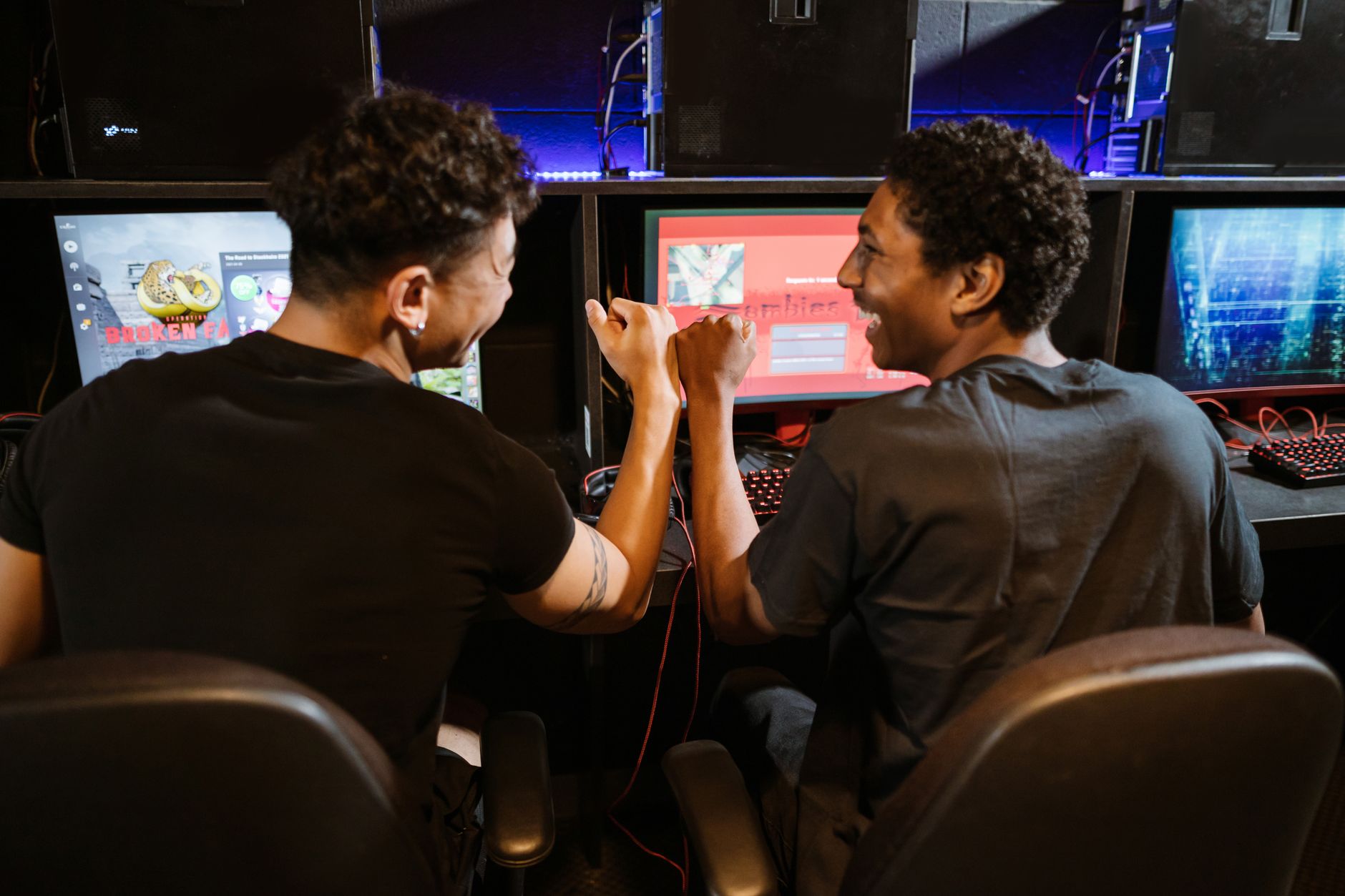 Two staff members discussing game setup in the arcade.